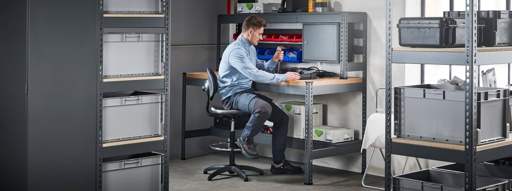 mann som sitter ved en arbeidsbenk