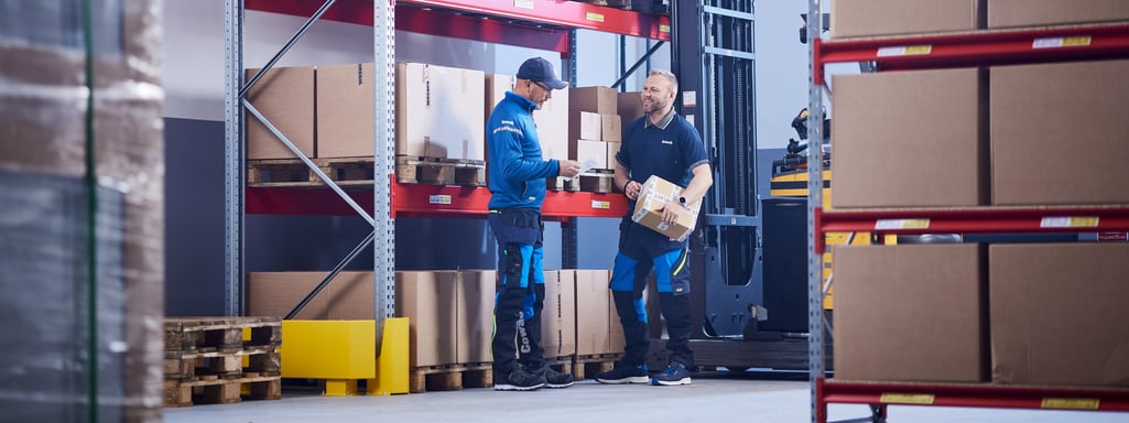 to menn som står ved et pallereol