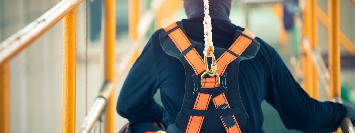 Person med sikkerhetsutstyr oppe i høyden. Foto