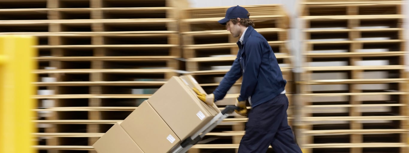 Mann bruker tralle fra Cowab til å transportere tung last. Foto