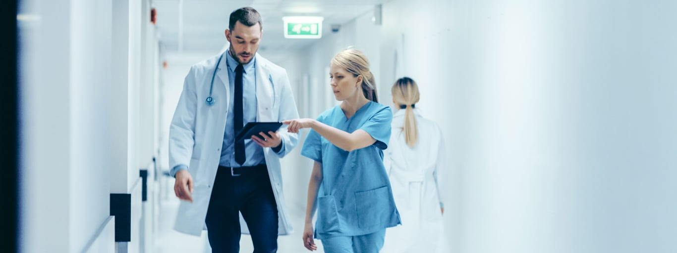 Lege og sykepleier snakker sammen. Foto