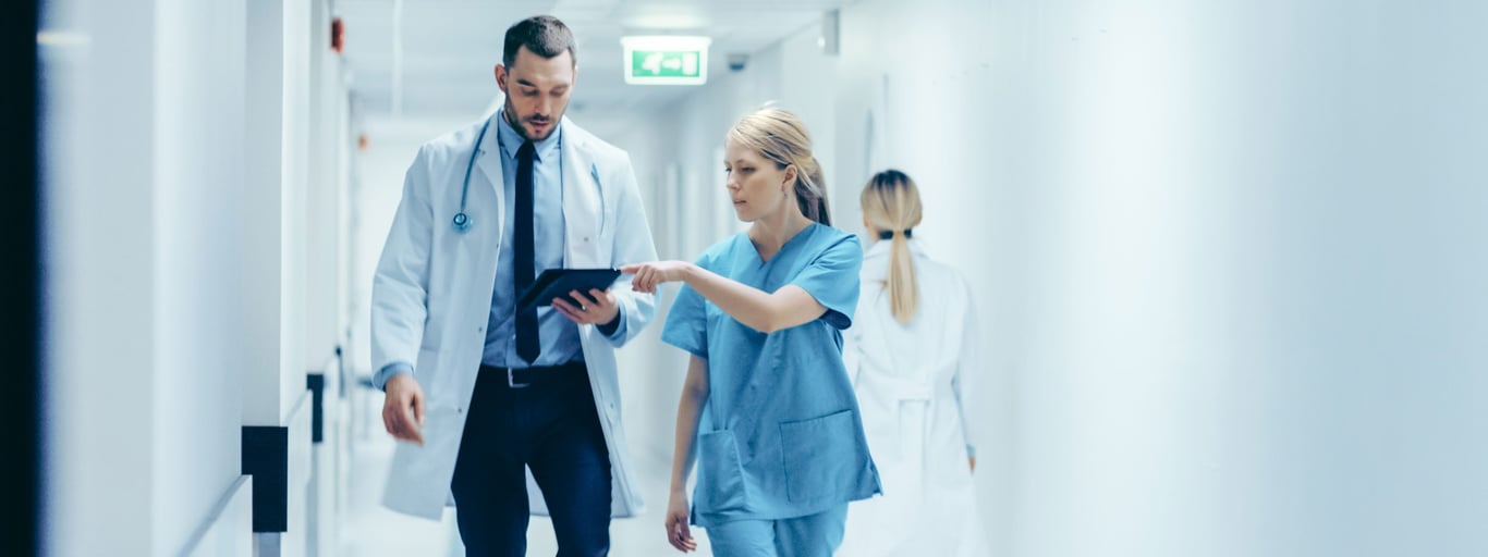 Lege og sykepleier snakker sammen. Foto