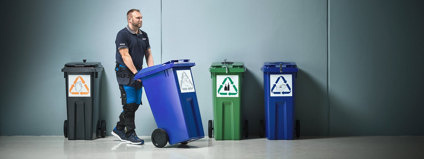 Man hanterar källsortering på jobbet. Foto