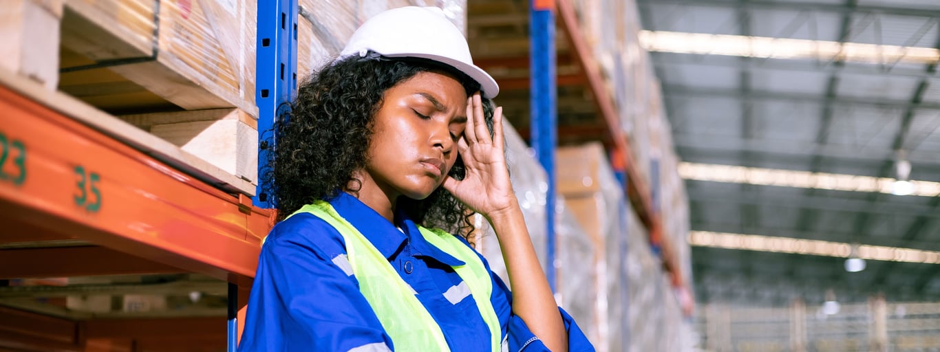 En kvinne på et lager føler seg syk. Foto