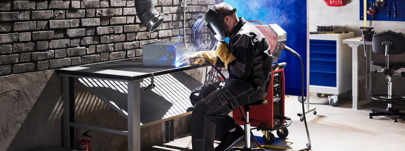 Mann arbeider ved sveisebord fra Cowab. Foto