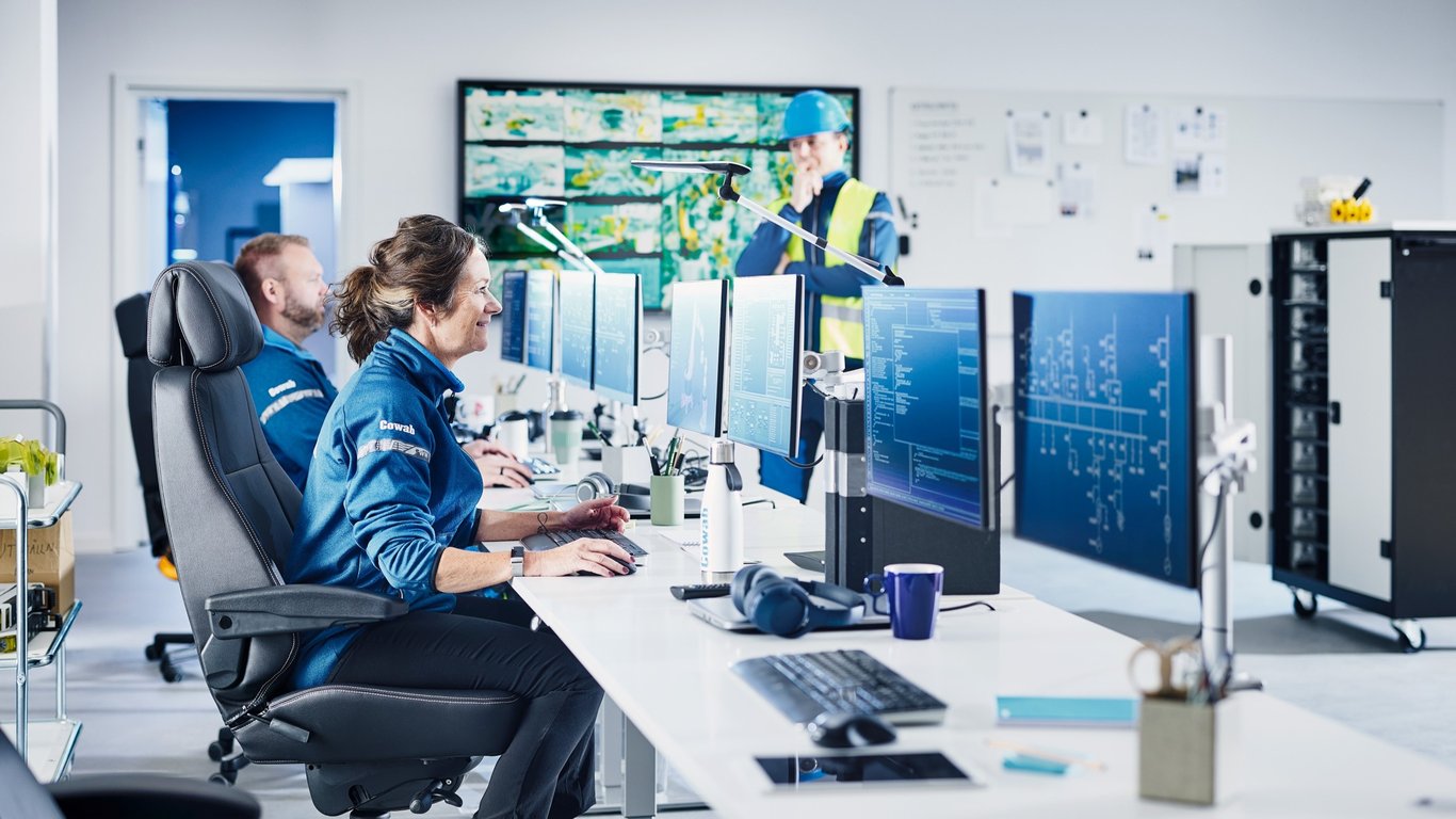 Två anställda arbetar på kontoret med ergonomisk utrustning från Cowab. Foto