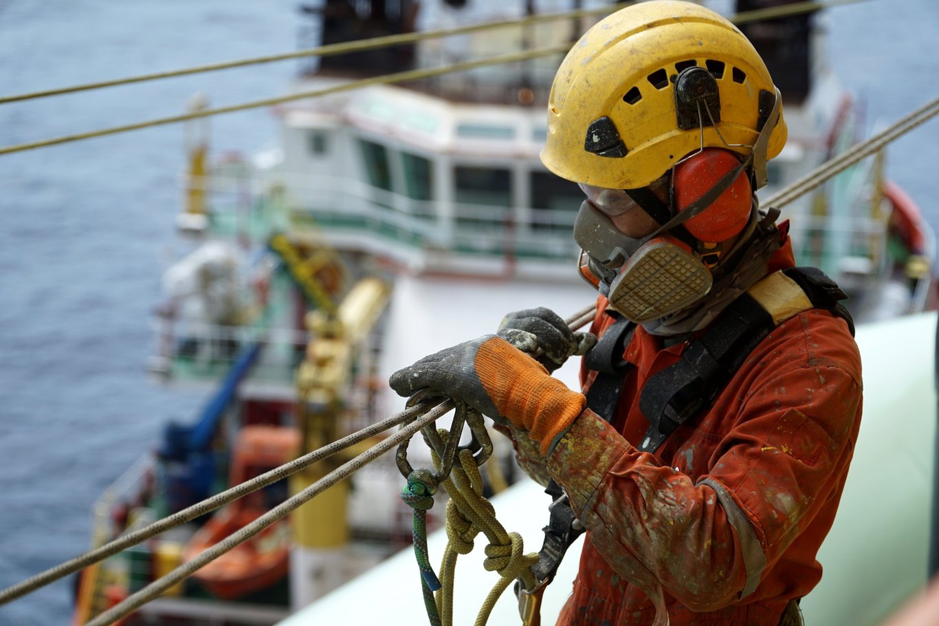 Mann på arbeidsplattform med beskyttelsesutstyr. Foto