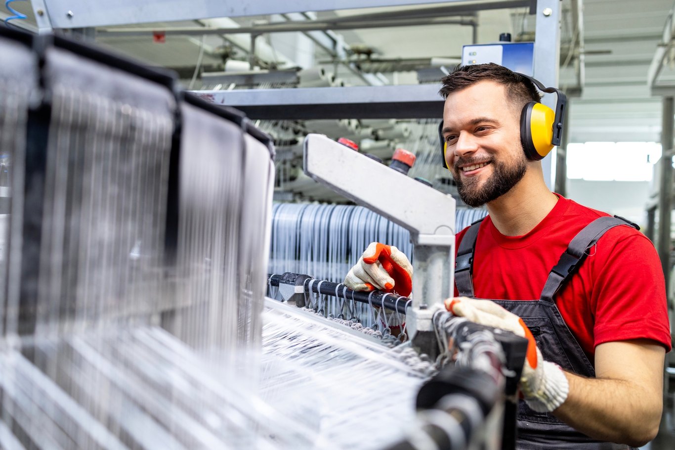 Mann jobber i plastfabrikk. Foto