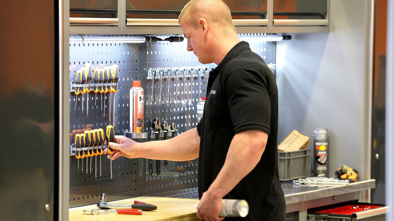 Mann foran verktøytavle. Foto