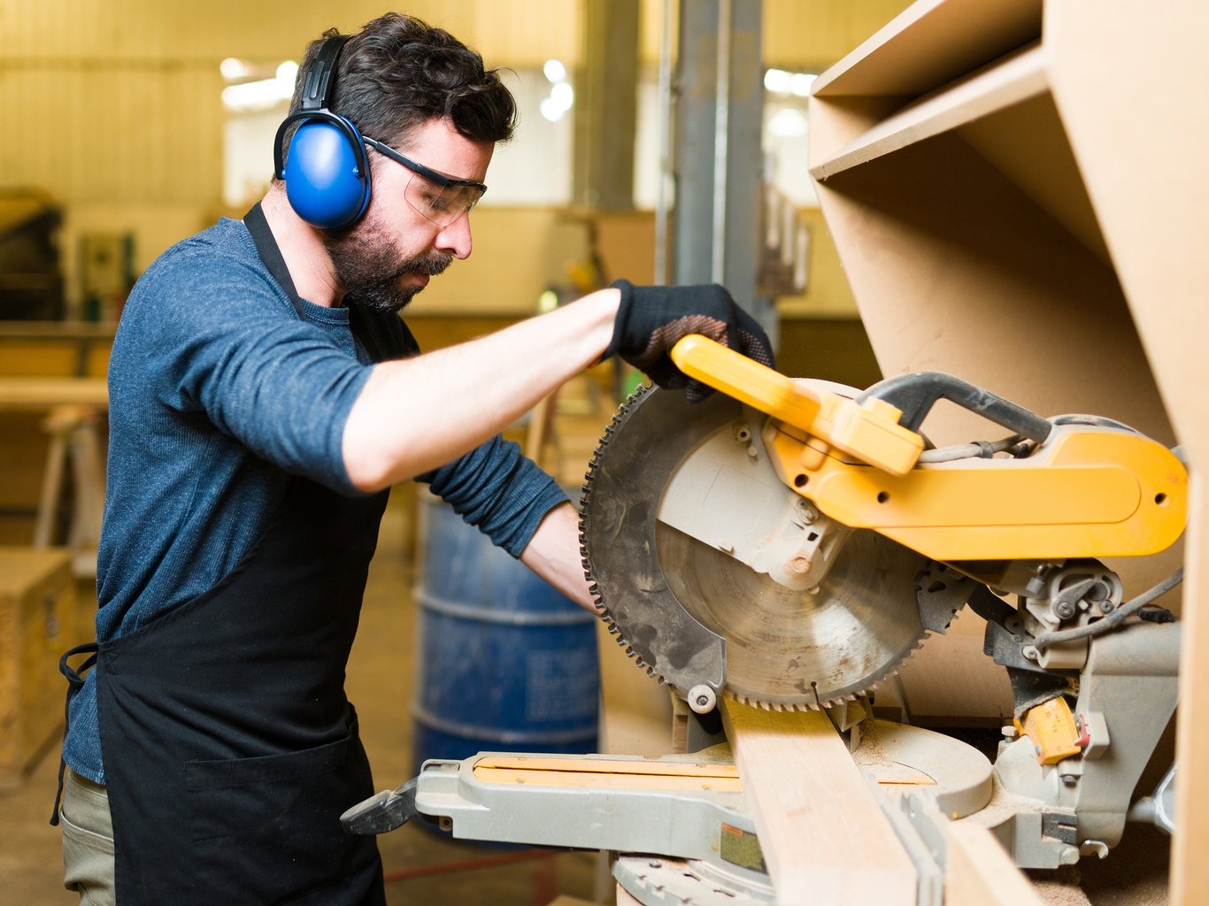 Mann ved maskin bruker hørselvern. Lyddemping, Cowab. Foto