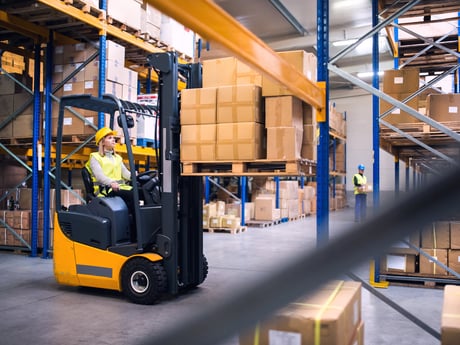 Kvinne kjører truck på lager. Foto