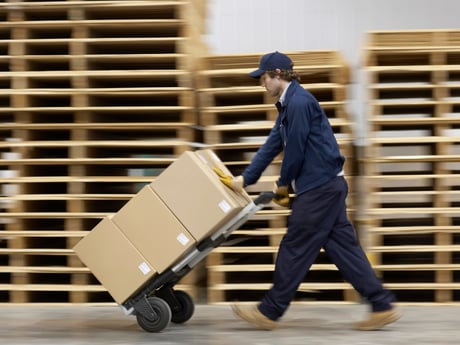 Mann bruker tralle fra Cowab til å transportere tung last. Foto