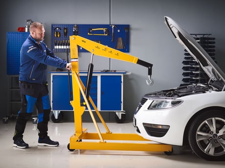 Mann med løftehjelpemiddel fra Cowab i verksted. Foto