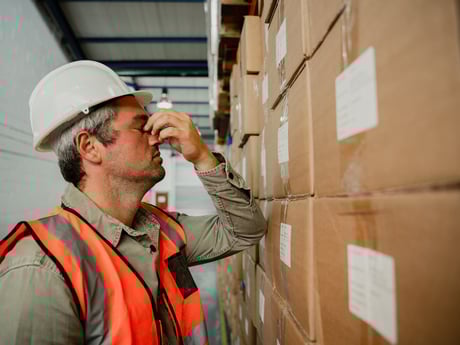 Mann på arbeidsplass holder seg på nesa. Foto