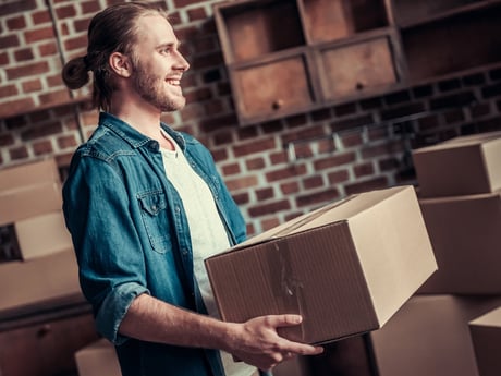 Mann med eske og riktig løfteteknikk. Foto