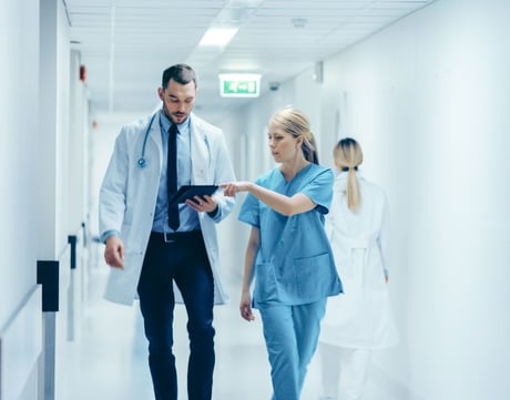 Lege og sykepleier snakker sammen. Foto