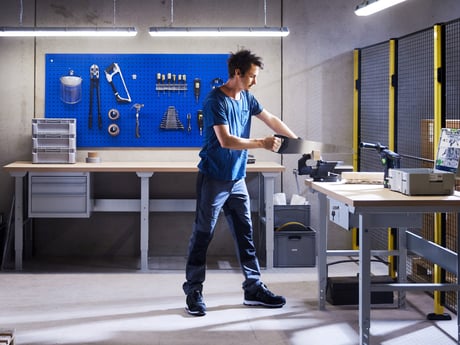 Mann arbeider på verksted med verkstedinnredning fra Cowab. Foto