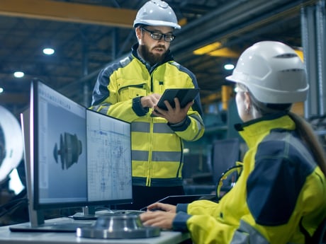 Mann og kvinne på lager diskuterer. Foto