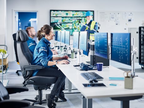 To personer sitter i et kontrollrom. Foto