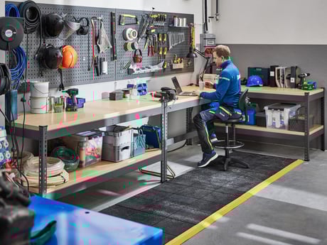 En mann som sitter ved en arbeidsbenk fra Cowab. Foto