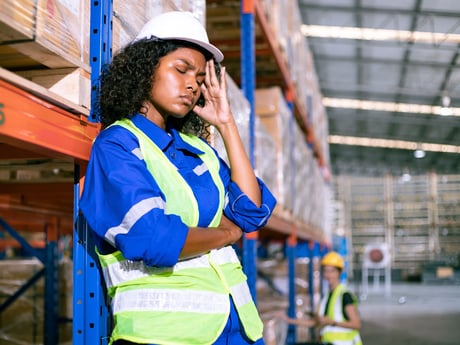En kvinne på et lager føler seg syk. Foto