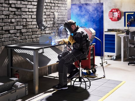 Mann arbeider ved sveisebord fra Cowab. Foto