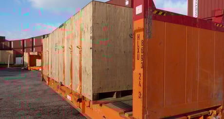 Oransje containere utendørs, lastsikring. Foto