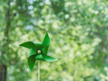 Vindkraftverk på grön bakgrund. Energi Cowab