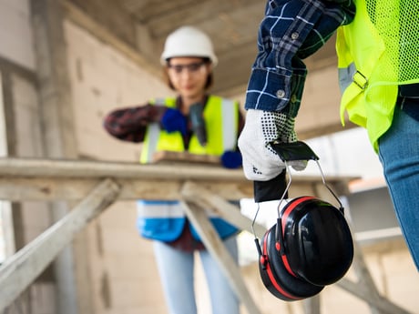 Mann og kvinne på arbeidsplass med hørselbeskyttelse. Foto