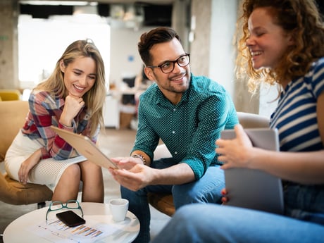Tre kollegaer snakker engasjert sammen. Foto