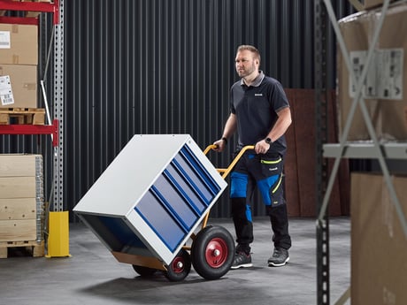 Man med magasinkärra från Cowab. Foto