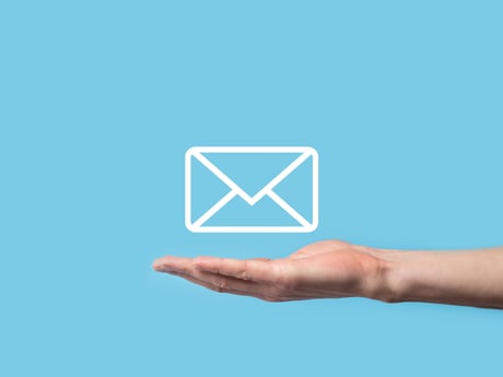 Svävande brev över en hand. Newsletter Cowab