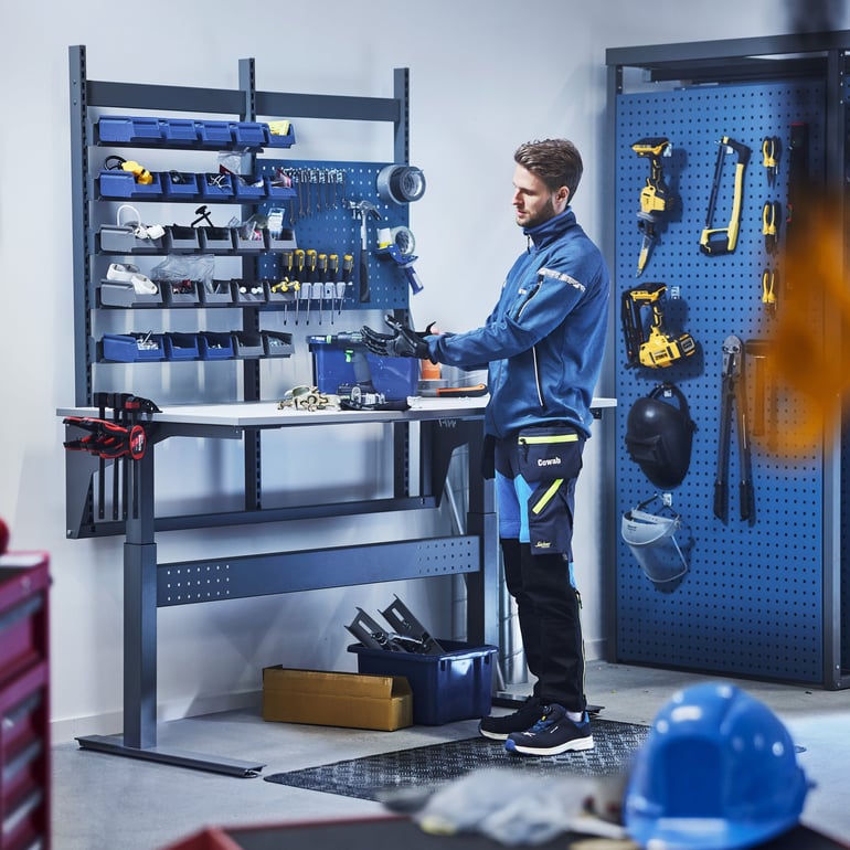 Mann som står ved en arbeidsbenk