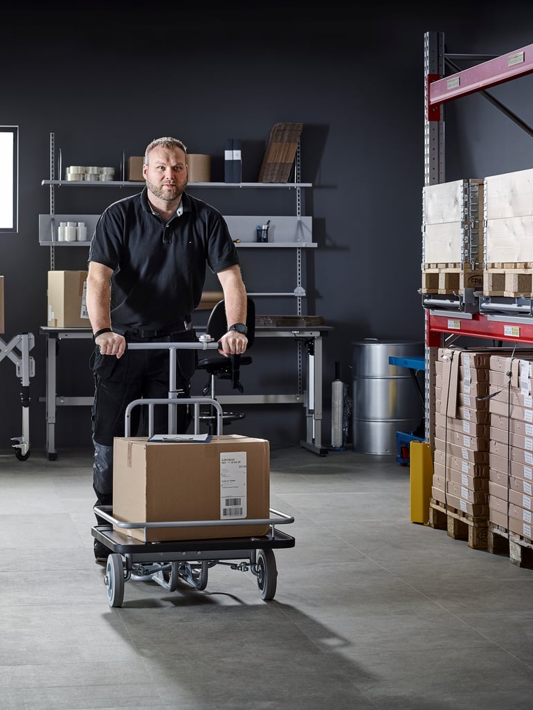 En mann som frakter varer på en scooter